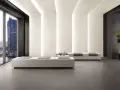 Interno moderno con pavimenti in kerlite cotto d'este, divani minimalisti e vista panoramica su una città illuminata.