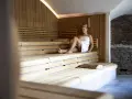 Donna rilassata in sauna, un'esperienza che distingue la differenza tra spa e terme per il benessere.