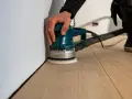 Levigatura del parquet: dopo quanto tempo si può camminare? La levigatrice orbitale lavora sul legno chiaro, pronto per essere calpestato.