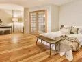 Camera mostra un letto, un armadio e un pavimento in legno. Il parquet è stato pulito con alcool, rendendolo brillante.