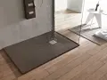 Piatto doccia filo pavimento con acqua che scorre verso la griglia. Design moderno e funzionale per un bagno elegante.