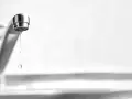 Un rubinetto perde acqua da sopra, goccia dopo goccia, uno spreco silenzioso.