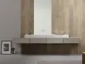 Bagno moderno con lavabo in marmo e specchio, su una parete rivestita con un elegante parquet a parete decorato con motivi geometrici.