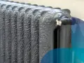 Dettaglio di termosifoni in ghisa con decorazioni floreali, pronti per il contenuto acqua.