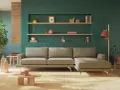 Divano beige davanti a un termosifone, con mensole piene di oggetti decorativi e piante.