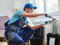 Tecnico con attrezzi lavora su termosifone. Scopri il lavaggio termosifoni in ghisa costo per un riscaldamento efficiente.