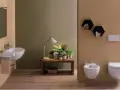 Bagno moderno con lavabo sospeso, bidet e vaso **ceramica globo**. Tavolino con piante e lampada.