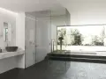 Bagno moderno con doccia a filo pavimento e vasca panoramica. Per un'esperienza rilassante, scopri come usare i sali da bagno nella doccia.