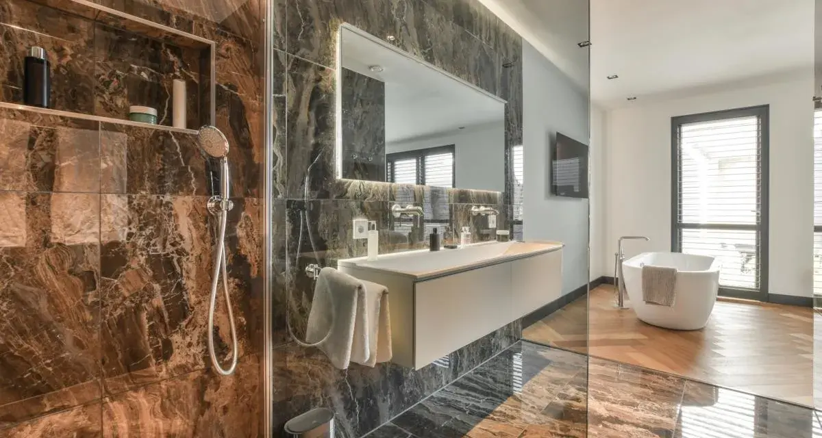 Bagno moderno con doccia, vasca e lavabo sospeso. La rubinetteria Bossini, con il suo design elegante, completa l'arredo di lusso.