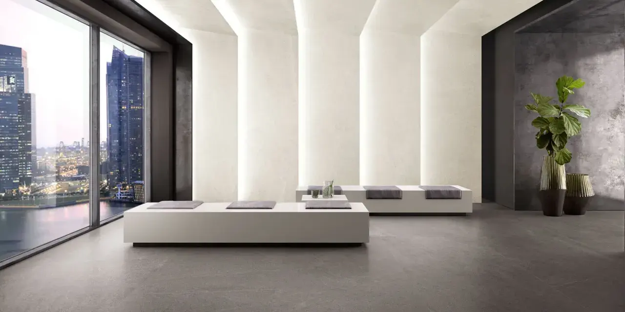 Interno moderno con pavimenti in kerlite cotto d'este, divani minimalisti e vista panoramica su una città illuminata.