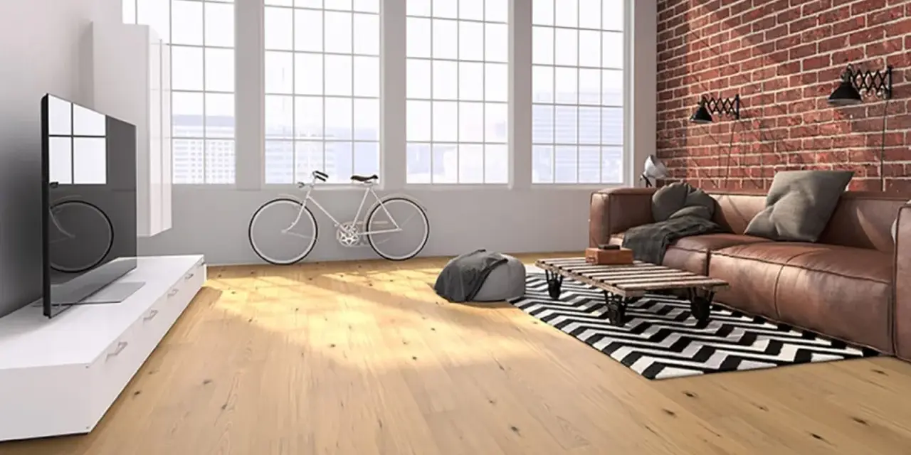 Soggiorno moderno con parquet effetto legno chiaro, divano in pelle, bici e mattoni a vista. Scopri i laminato Skema prezzi.