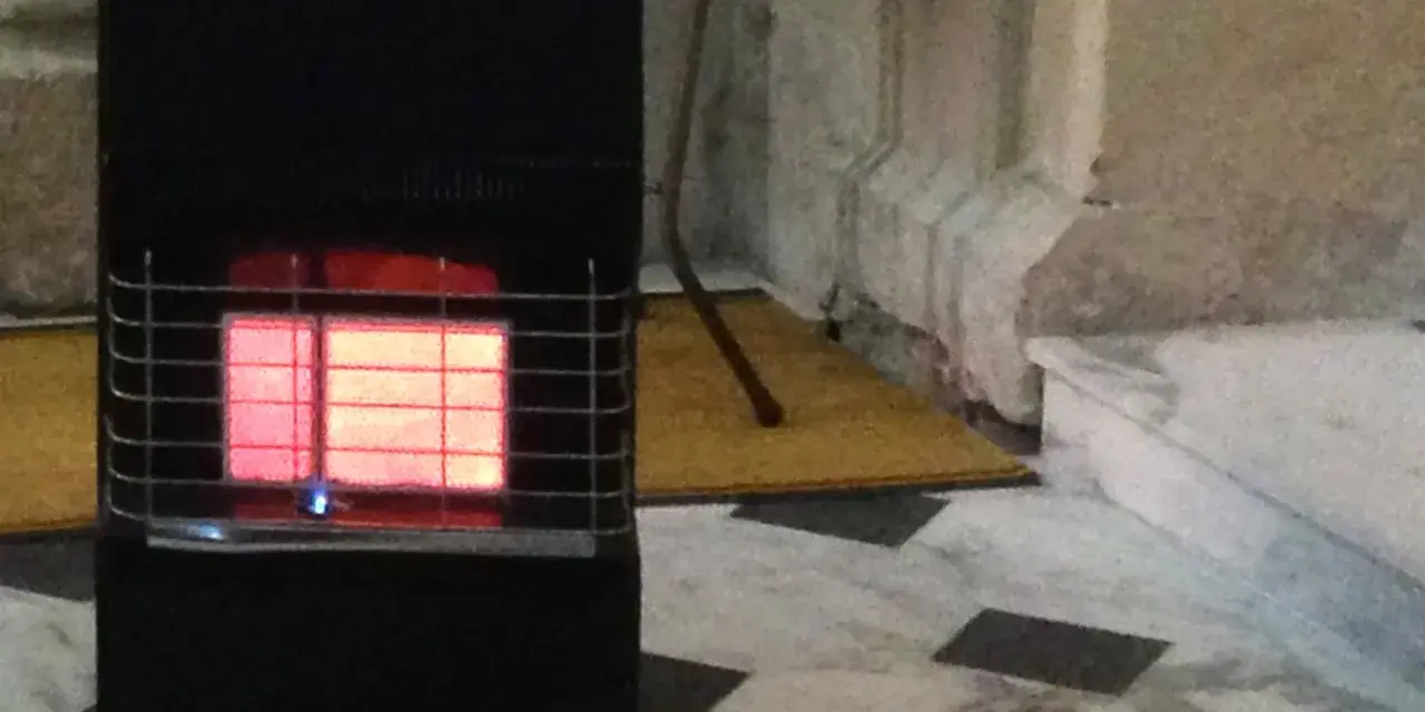 Stufa a gas nera con fiamma rossa visibile. Le stufe a gas sono sicure, offrono calore e comfort in casa.