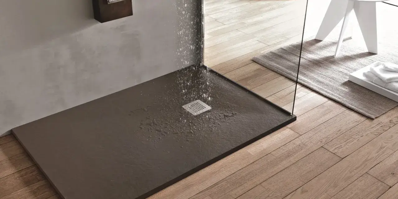 Piatto doccia filo pavimento con acqua che scorre verso la griglia. Design moderno e funzionale per un bagno elegante.