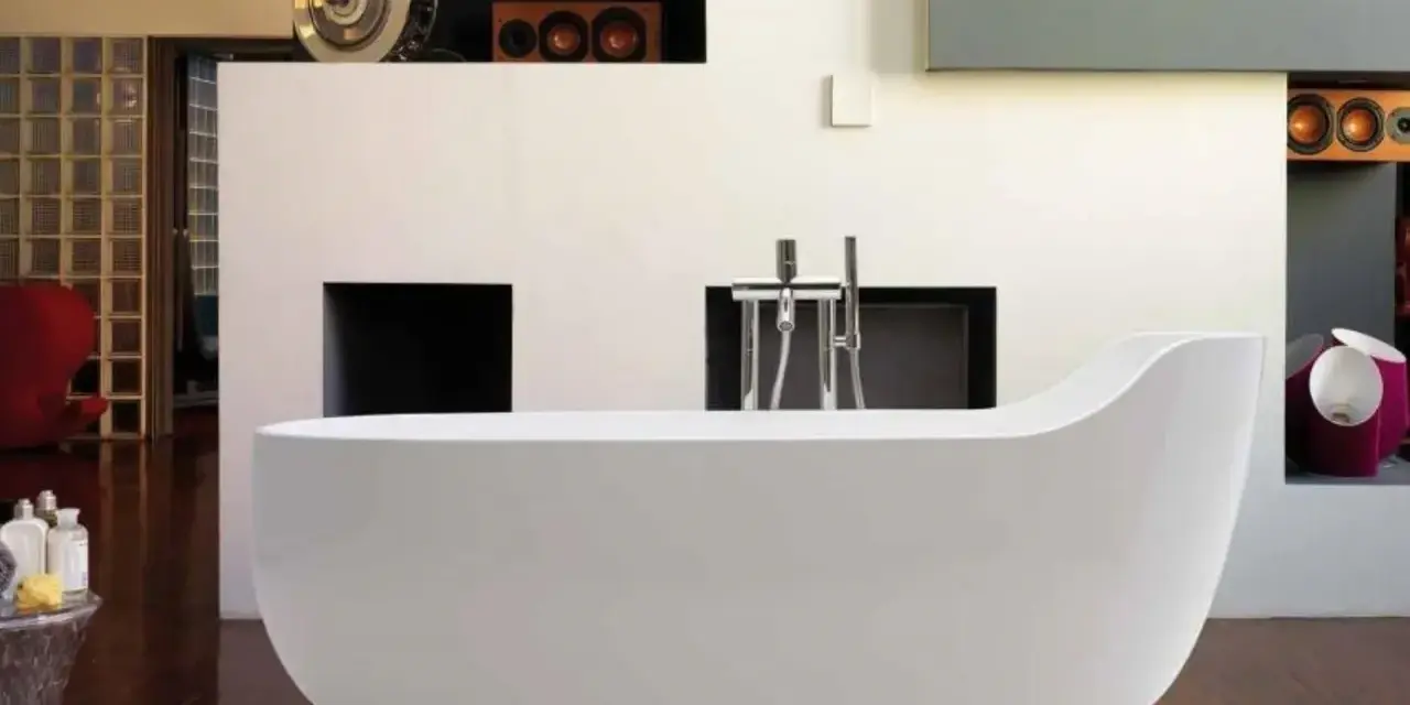 Una vasca da bagno bianca, simile a un globo, domina la scena. L'arredamento moderno include una parete con nicchie e un rubinetto cromato.