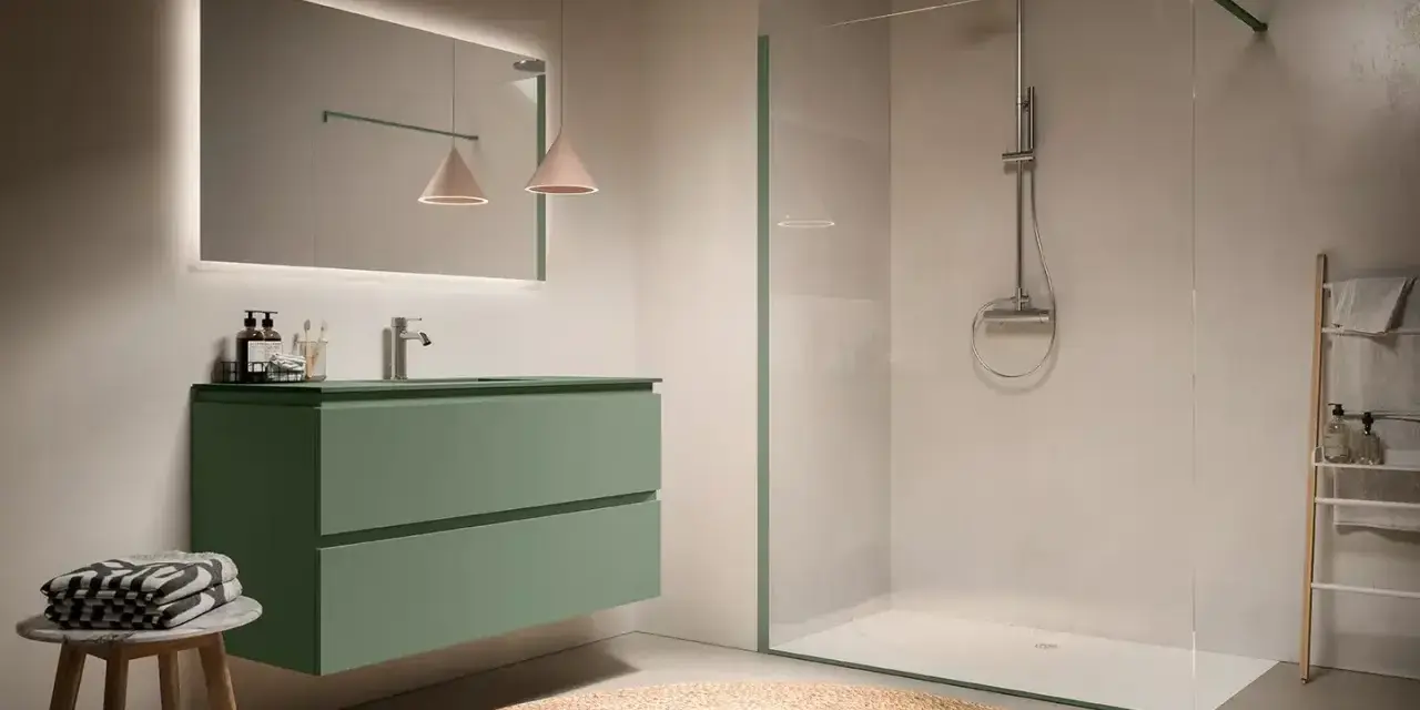 Bagno moderno con mobile sospeso verde acqua, specchio illuminato e doccia walk-in con pannelli in vetro, eleganti soluzioni doccia senza box.