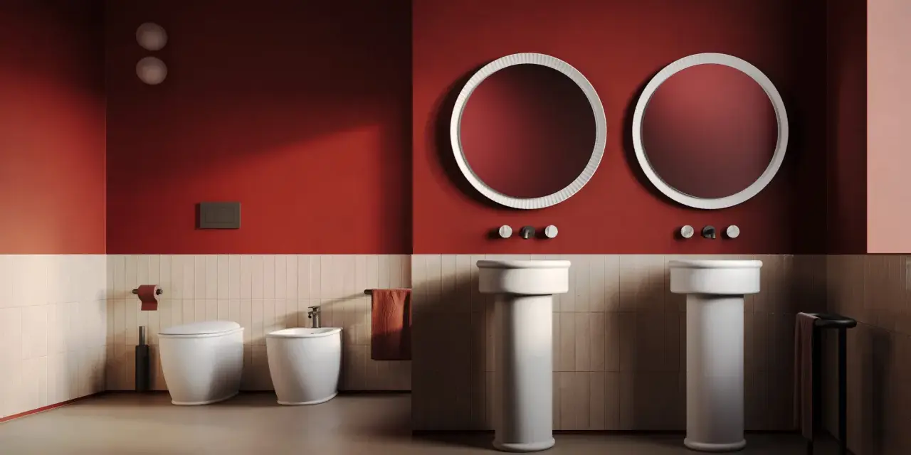 Bagno moderno con wc, bidet e due lavabi a colonna. L'artceramica bianca risalta sulle pareti rosse e le piastrelle chiare.