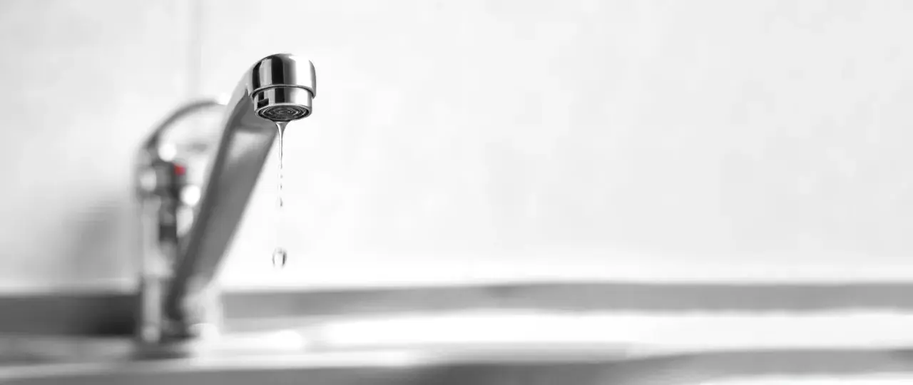 Un rubinetto perde acqua da sopra, goccia dopo goccia, uno spreco silenzioso.