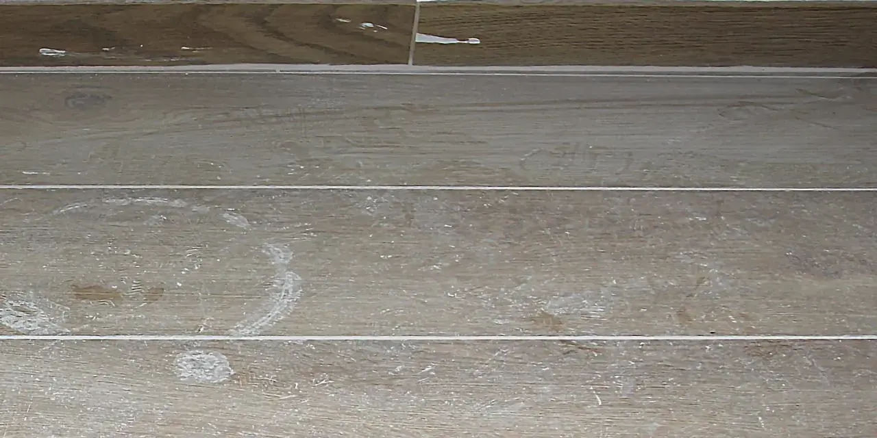 Stucco bianco residuo su piastrelle effetto legno. Ecco come togliere lo stucco dalle piastrelle per un risultato impeccabile.