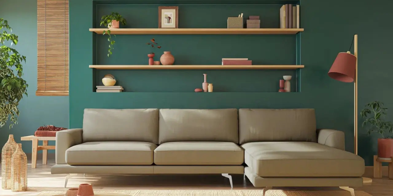 Divano beige davanti a un termosifone, con mensole piene di oggetti decorativi e piante.