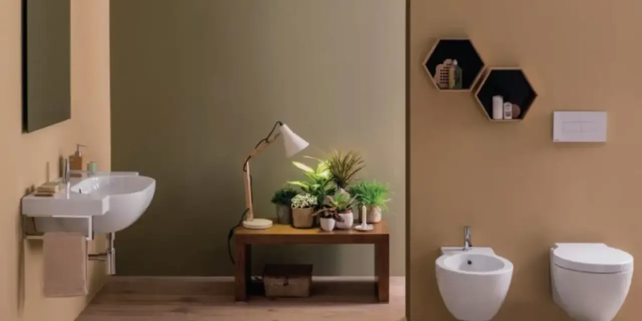 Bagno moderno con lavabo sospeso, bidet e vaso **ceramica globo**. Tavolino con piante e lampada.