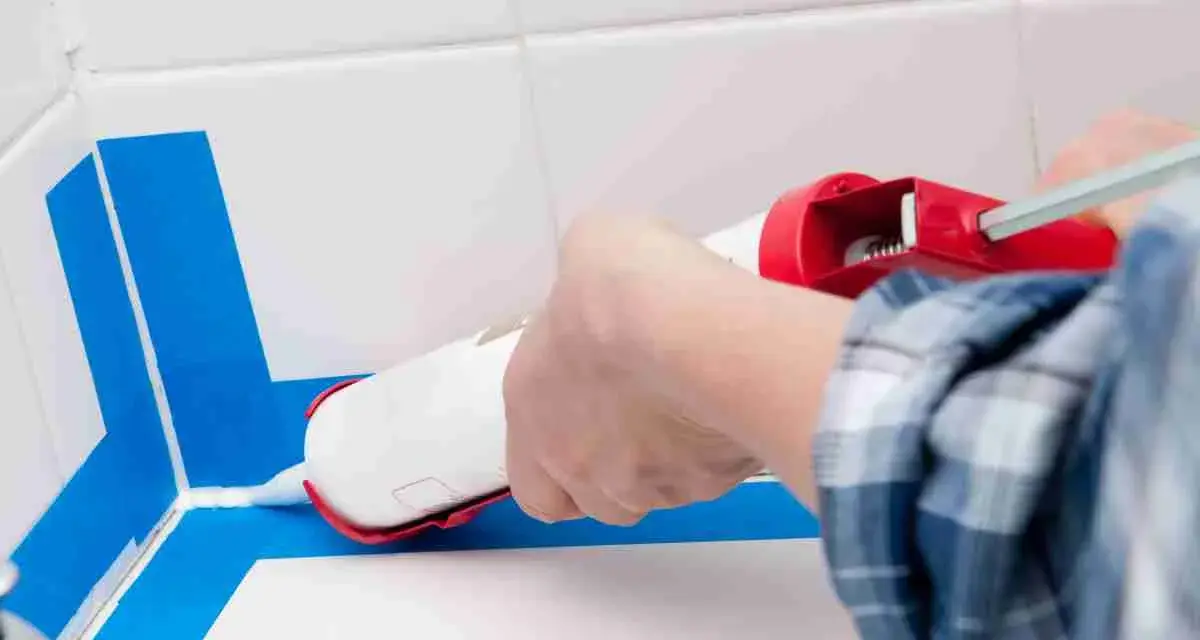 Applicazione sigillante per una doccia senza piatto, impermeabilizzazione perfetta con nastro blu.