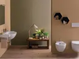 Bagno moderno con lavabo sospeso, bidet e vaso **ceramica globo**. Tavolino con piante e lampada.