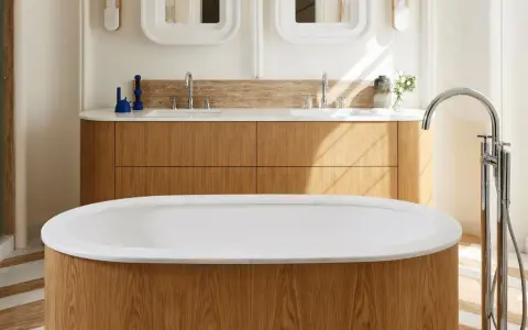 Una vasca da bagno di lusso con finiture in legno e marmo, rubinetteria cromata e un mobile doppio lavabo in legno.