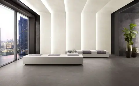 Interno moderno con pavimenti in kerlite cotto d'este, divani minimalisti e vista panoramica su una città illuminata.