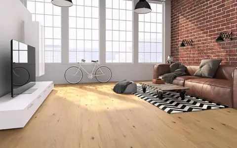 Soggiorno moderno con parquet effetto legno chiaro, divano in pelle, bici e mattoni a vista. Scopri i laminato Skema prezzi.
