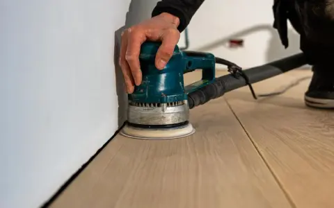 Levigatura del parquet: dopo quanto tempo si può camminare? La levigatrice orbitale lavora sul legno chiaro, pronto per essere calpestato.
