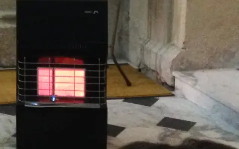 Stufa a gas nera con fiamma rossa visibile. Le stufe a gas sono sicure, offrono calore e comfort in casa.