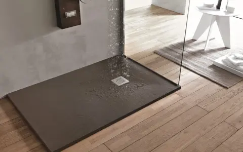 Piatto doccia filo pavimento con acqua che scorre verso la griglia. Design moderno e funzionale per un bagno elegante.