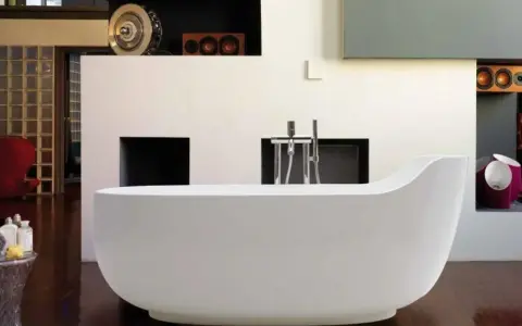 Una vasca da bagno bianca, simile a un globo, domina la scena. L'arredamento moderno include una parete con nicchie e un rubinetto cromato.