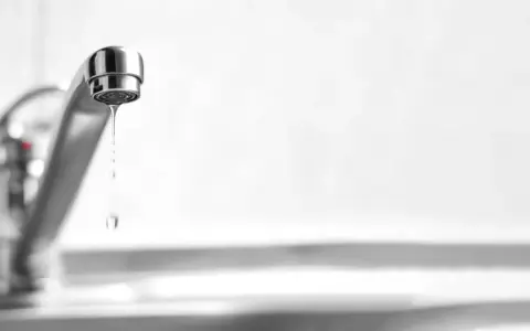 Un rubinetto perde acqua da sopra, goccia dopo goccia, uno spreco silenzioso.