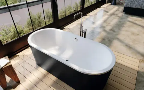 Vasca da bagno freestanding nera con rubinetteria cromata. Le misure della vasca da bagno sono ideali per un bagno moderno con vista sul giardino.
