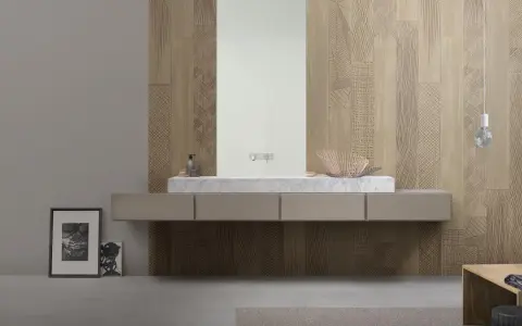 Bagno moderno con lavabo in marmo e specchio, su una parete rivestita con un elegante parquet a parete decorato con motivi geometrici.