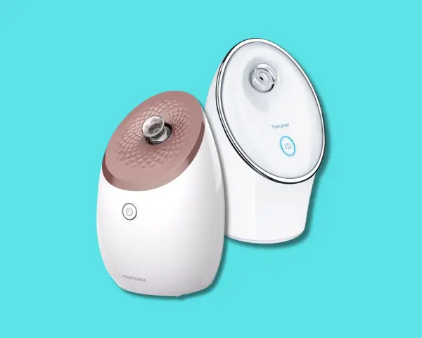 Due vaporizzatori facciali, uno Medisana e uno Beurer, su sfondo azzurro. Utili per la cura della pelle, ma attenzione alle sauna facciale controindicazioni.