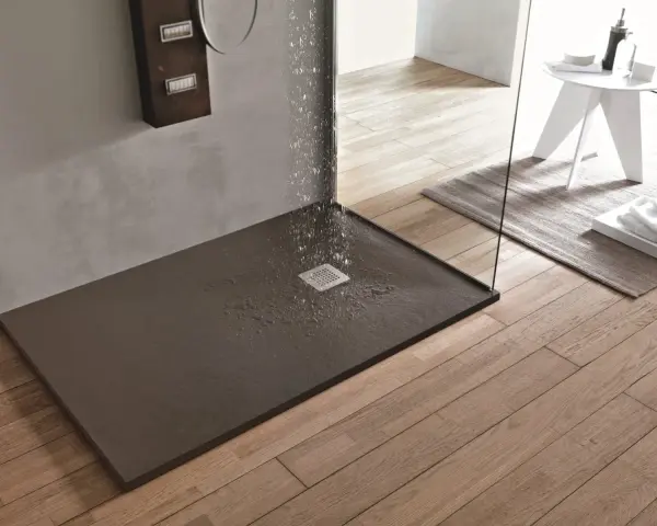 Piatto doccia filo pavimento con acqua che scorre verso la griglia. Design moderno e funzionale per un bagno elegante.
