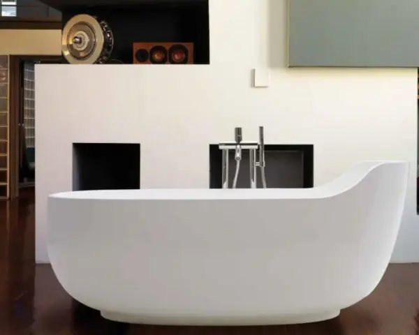 Una vasca da bagno bianca, simile a un globo, domina la scena. L'arredamento moderno include una parete con nicchie e un rubinetto cromato.
