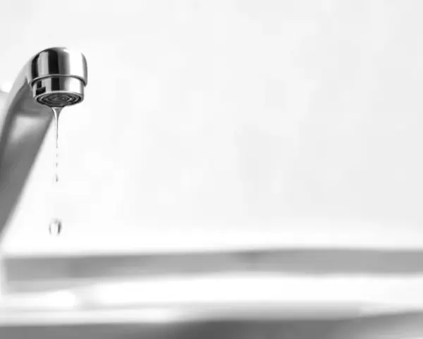 Un rubinetto perde acqua da sopra, goccia dopo goccia, uno spreco silenzioso.