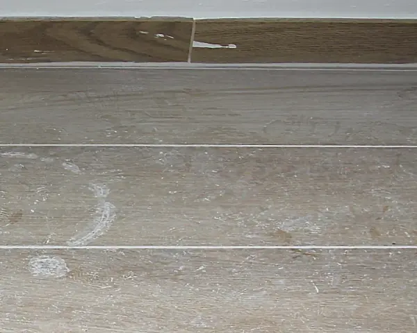 Stucco bianco residuo su piastrelle effetto legno. Ecco come togliere lo stucco dalle piastrelle per un risultato impeccabile.
