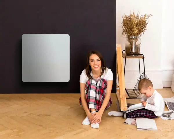 Donna e bambino in un soggiorno con pannelli radianti infrarossi. Nessuna controindicazione visibile.