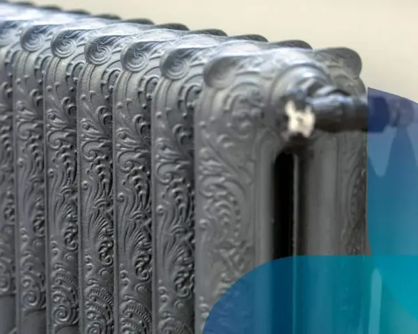 Dettaglio di termosifoni in ghisa con decorazioni floreali, pronti per il contenuto acqua.