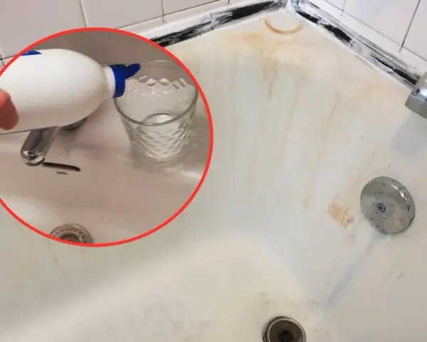 Un bicchiere viene riempito con un liquido da una bottiglia bianca, un passo per imparare come pulire la vasca da bagno macchiata.