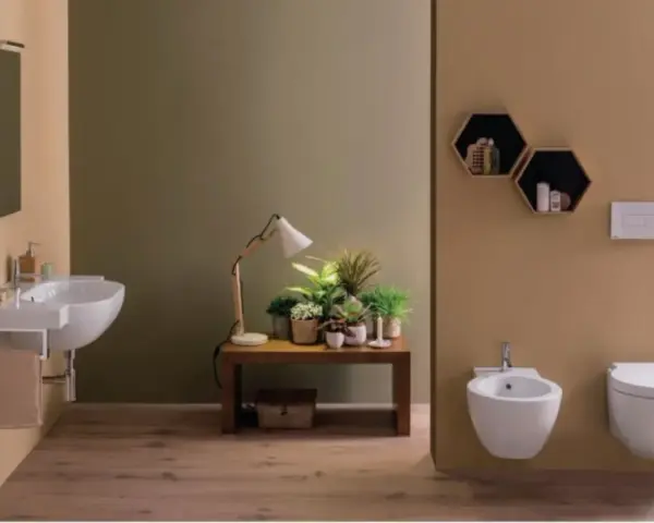 Bagno moderno con lavabo sospeso, bidet e vaso **ceramica globo**. Tavolino con piante e lampada.