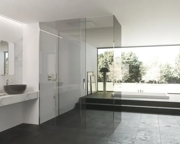 Bagno moderno con doccia a filo pavimento e vasca panoramica. Per un'esperienza rilassante, scopri come usare i sali da bagno nella doccia.