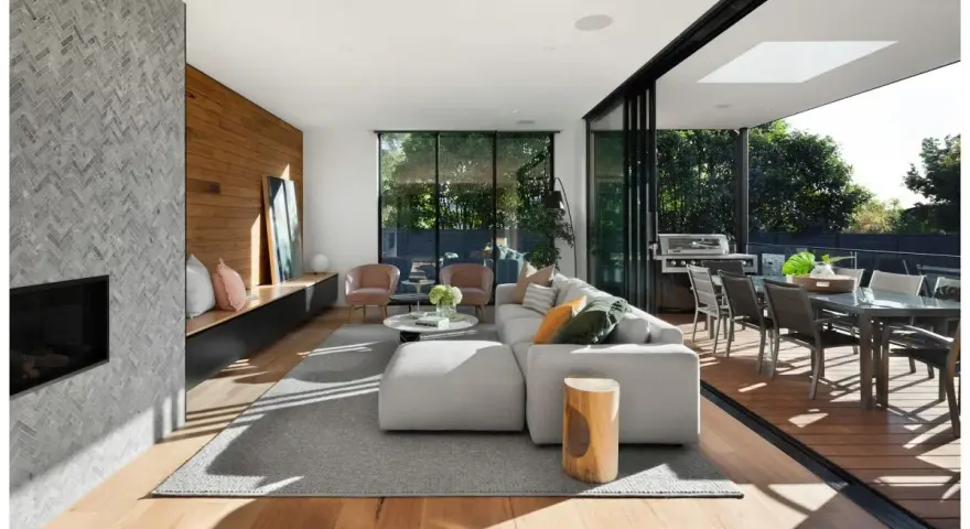 Soggiorno moderno con camino in pietra, divano bianco, e un bellissimo parquet essenze che si estende verso l'esterno, collegandosi alla zona pranzo esterna.