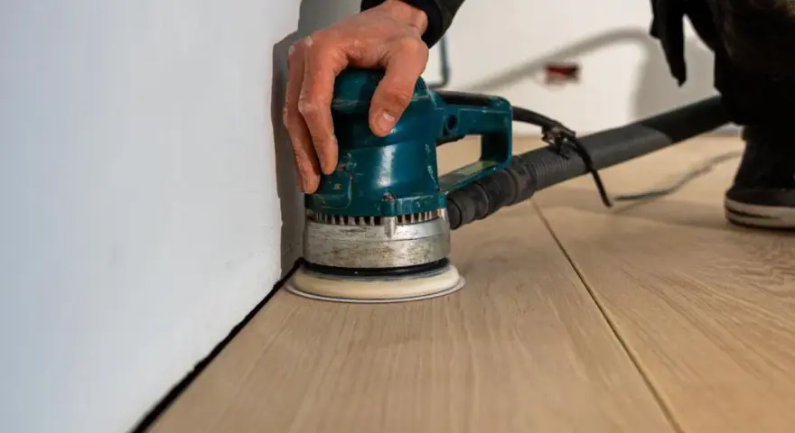 Levigatura del parquet: dopo quanto tempo si può camminare? La levigatrice orbitale lavora sul legno chiaro, pronto per essere calpestato.