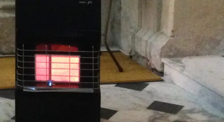 Stufa a gas nera con fiamma rossa visibile. Le stufe a gas sono sicure, offrono calore e comfort in casa.