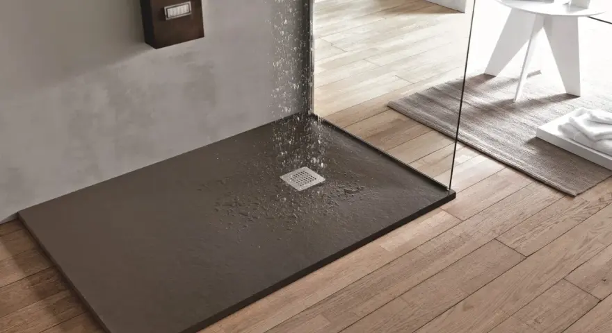Piatto doccia filo pavimento con acqua che scorre verso la griglia. Design moderno e funzionale per un bagno elegante.